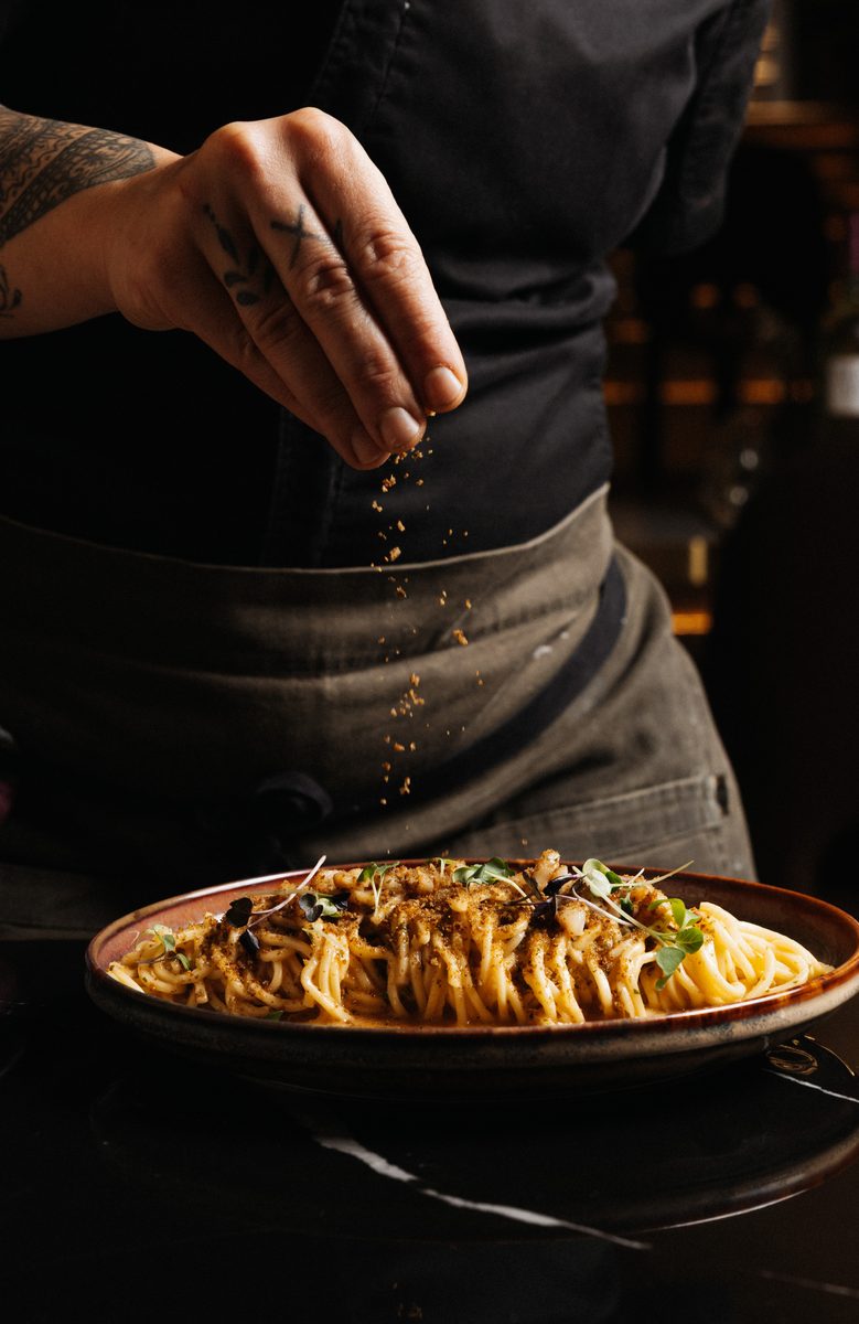Our chef finishing a plate of handmade pasta